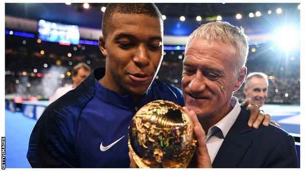 Kylian Mbappe und Didier Deschamps bewundern den WM-Pokal.