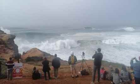 Zuschauer beobachten die Wellen vom Leuchtturm in der Nähe von Nazare.