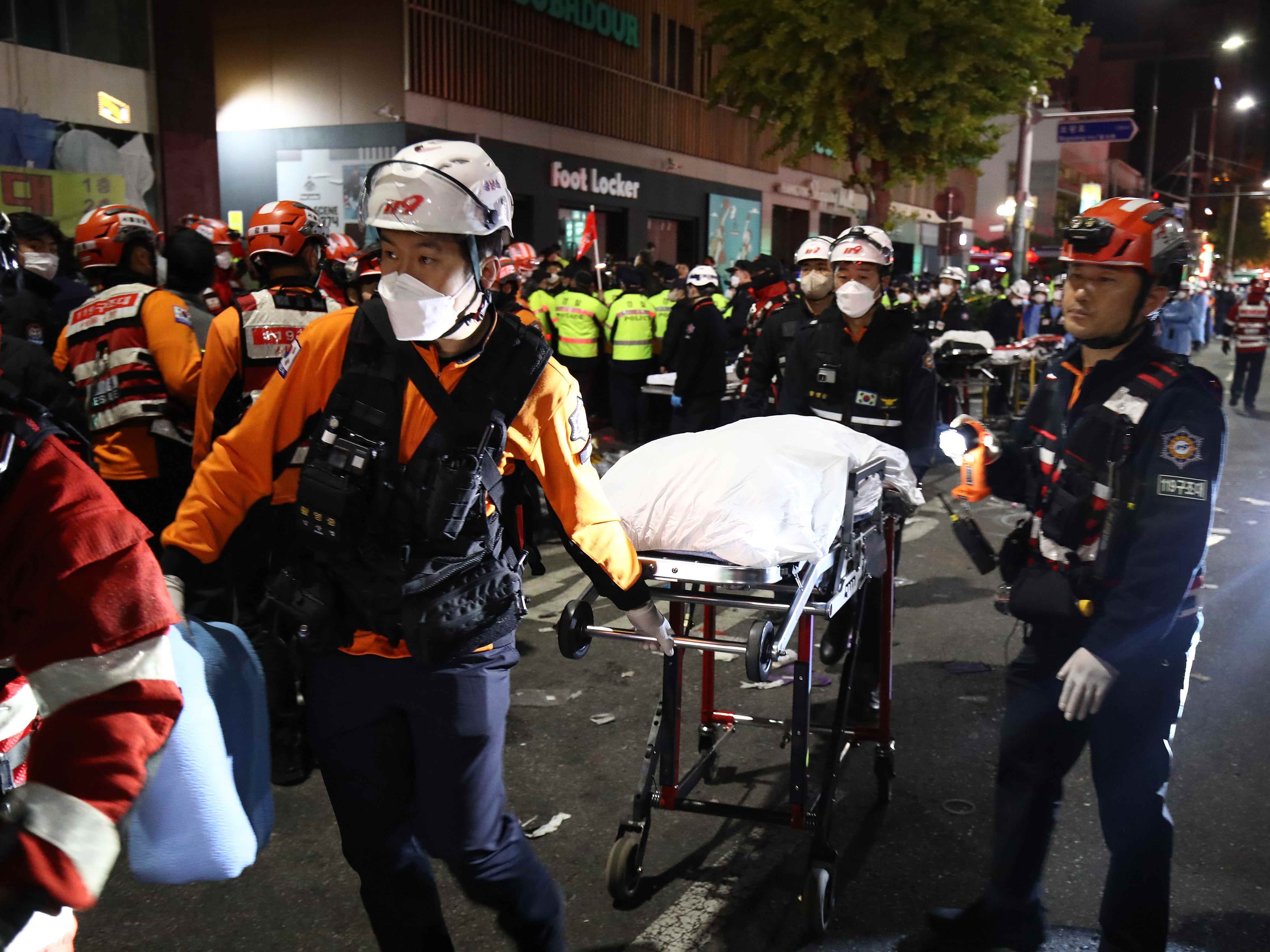 Rettungsdienste transportieren eine Person nach einem Ansturm während einer Halloween-Feier in Seoul, Südkorea.