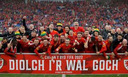 Der walisische Kader feiert den Sieg und die Qualifikation für die Weltmeisterschaft hinter einer Tafel, auf der Walisisch steht "Danke an die Rote Wand" nach dem WM-Playoff-Endspiel zwischen Wales und der Ukraine im Cardiff City Stadium im Juni 2022.