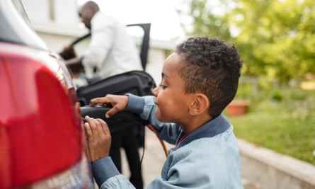 Seitenansicht eines Jungen, der beim Aufladen des Elektroautos schaut