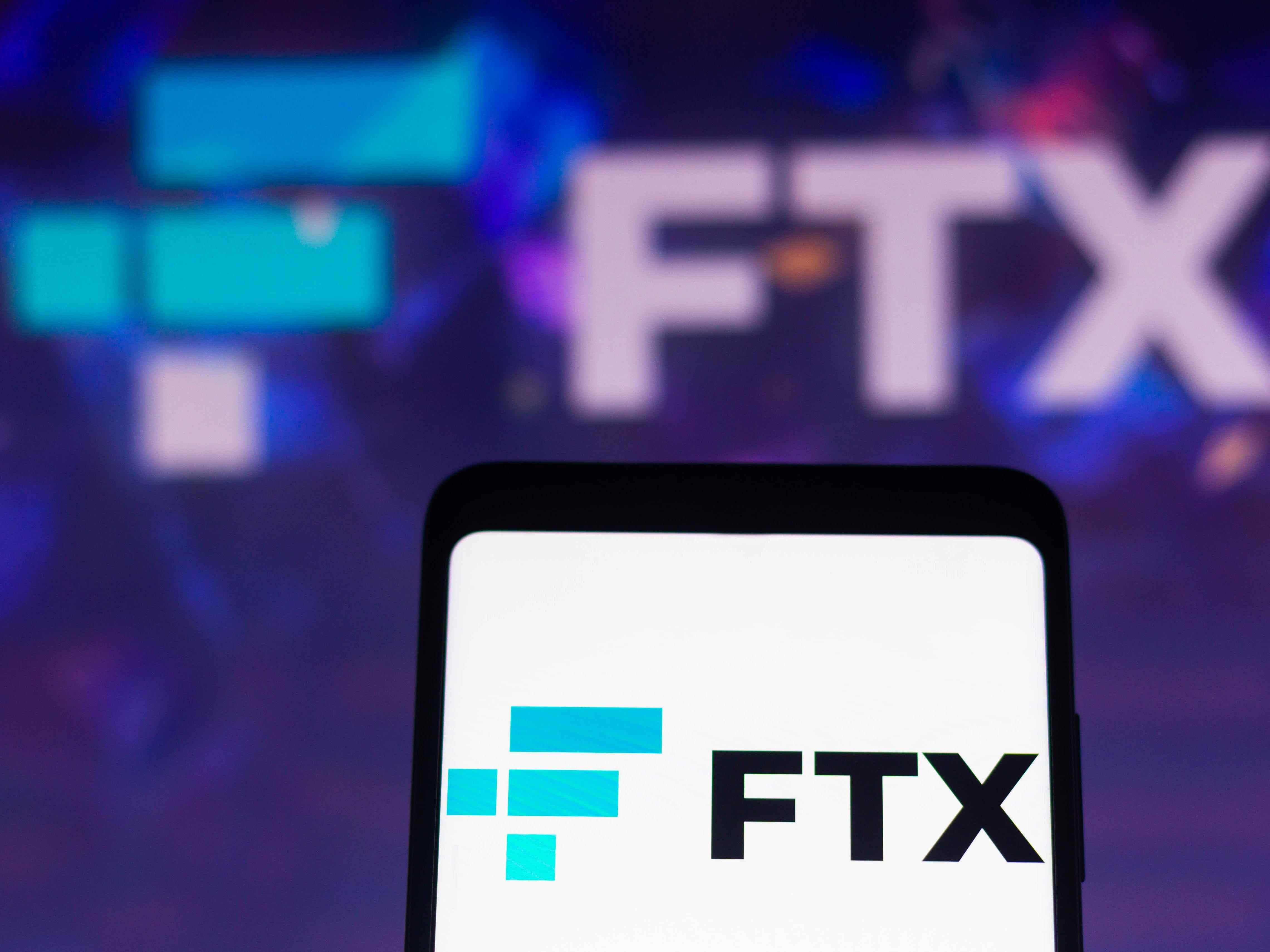 In dieser Abbildung wird das Logo der FTX Crypto Derivatives Exchange auf einem Smartphone-Bildschirm und im Hintergrund angezeigt.