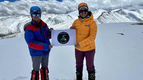 Malavath und Manyapu halten auf dem Gipfel ihr Project Shakthi-Logo hoch.