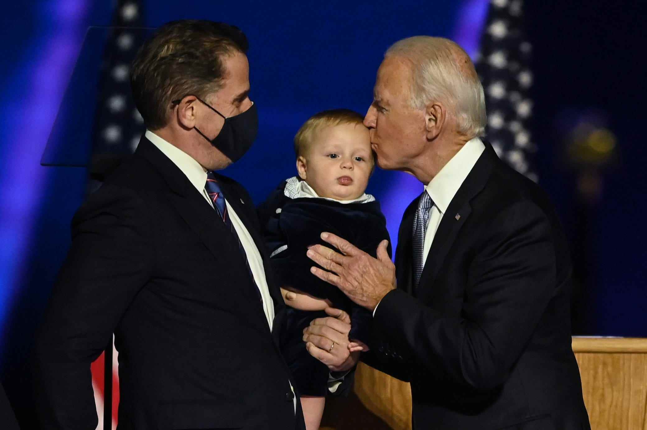Joe Biden küsst seinen von Hunter Biden gehaltenen Enkel