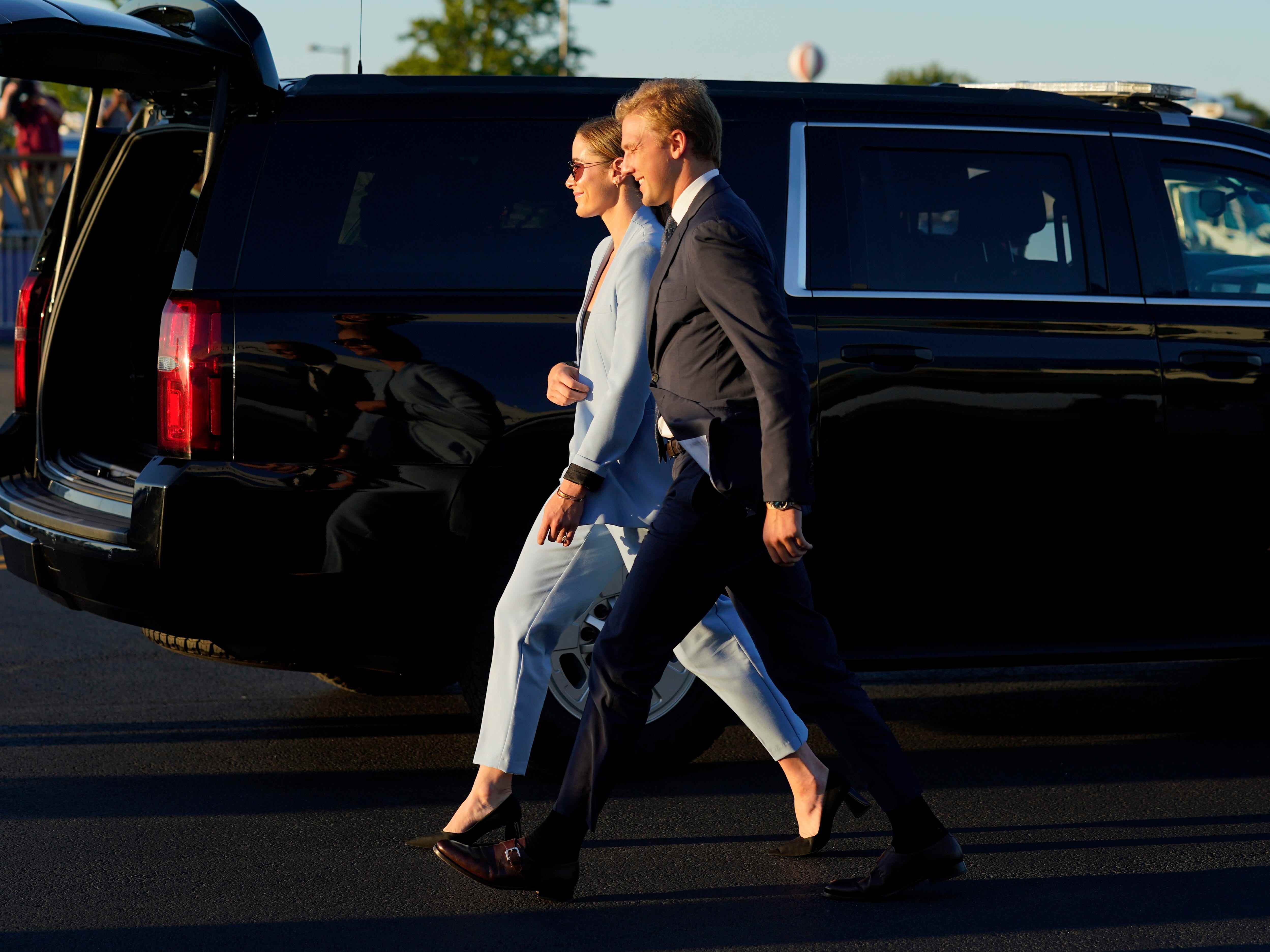 Naomi Biden und ihr Verlobter Peter Neal laufen vor einem schwarzen Präsidentenauto