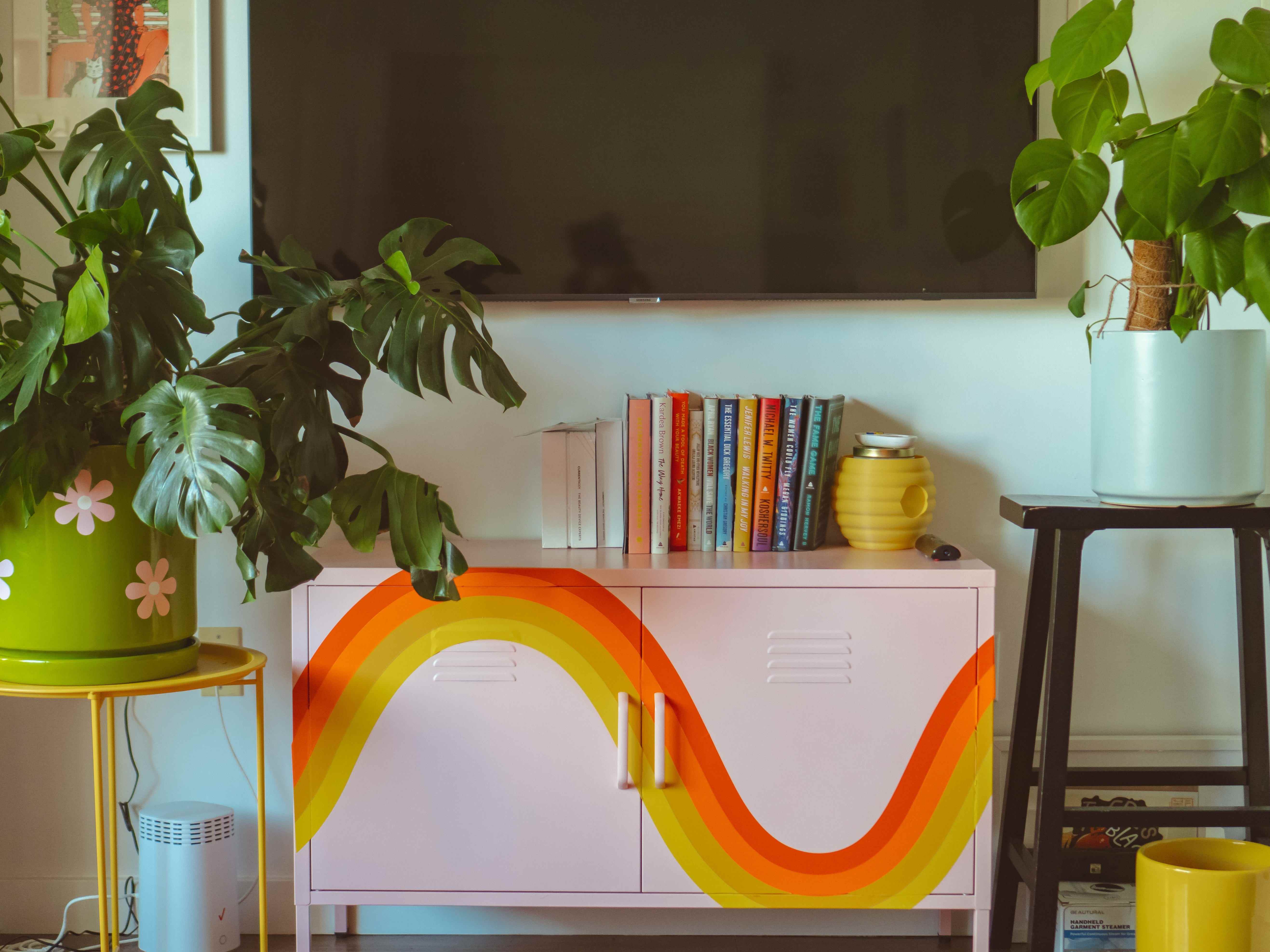 Ein rosafarbener Schließfachschrank mit einem orange-gelben Regenbogen-Aufkleber darauf