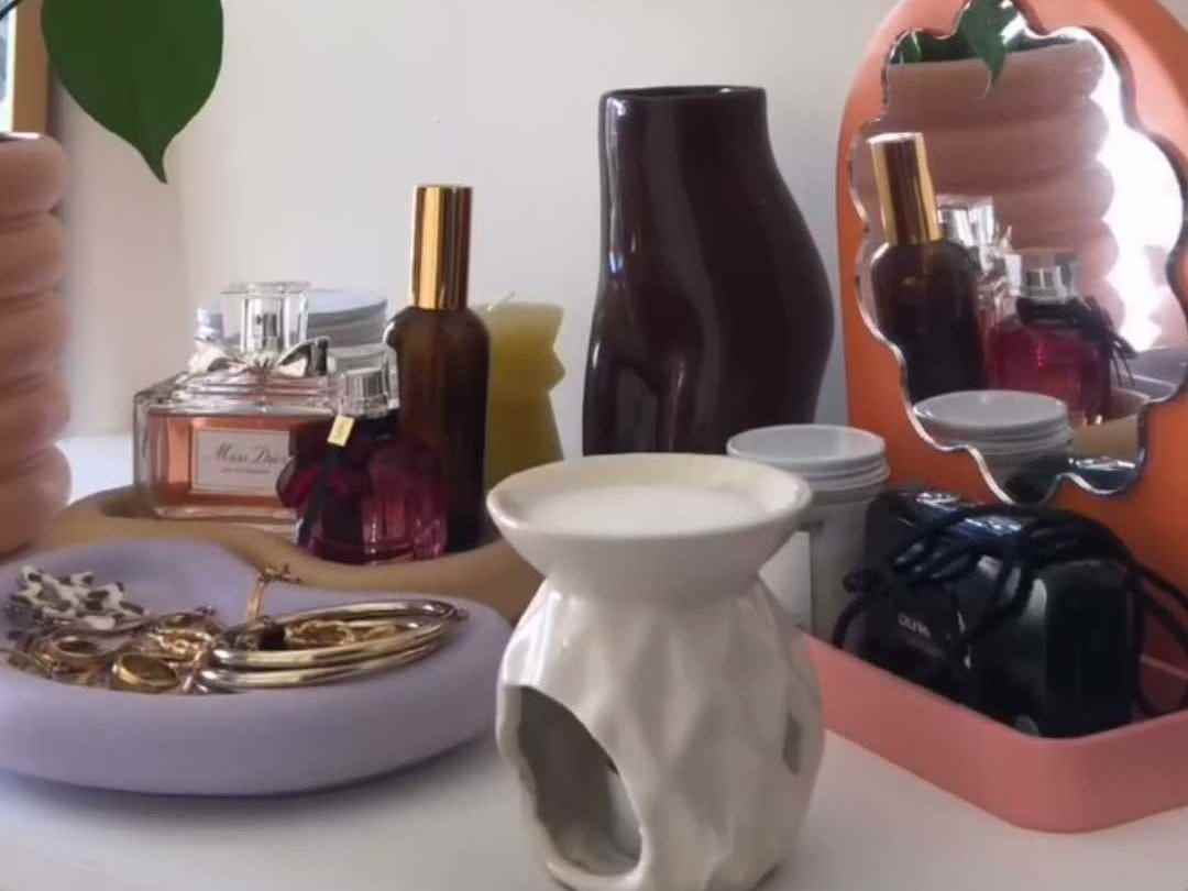 Ein Tisch voller Schmuckgeschirr, Topfpflanzen, einem Spiegel und Vasen