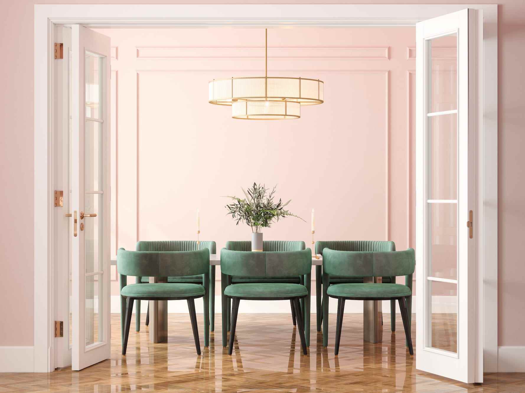 Ein rosa Esszimmer mit grünen Stühlen.