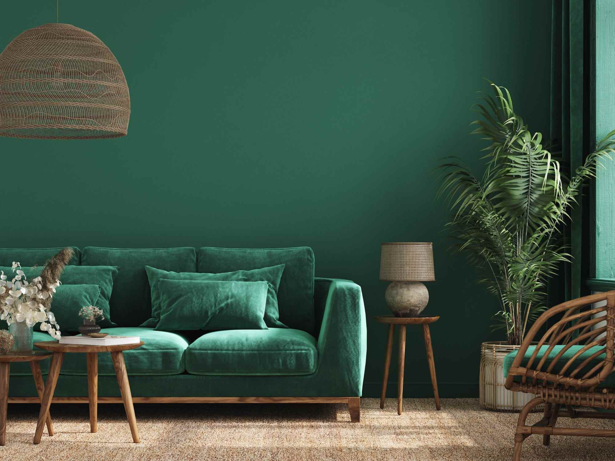 Ein Wohnzimmer mit grünen Wänden und einer grünen Couch.