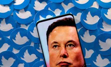 Abbildung zeigt Elon Musk-Bild auf Smartphone und gedruckte Twitter-Logos.