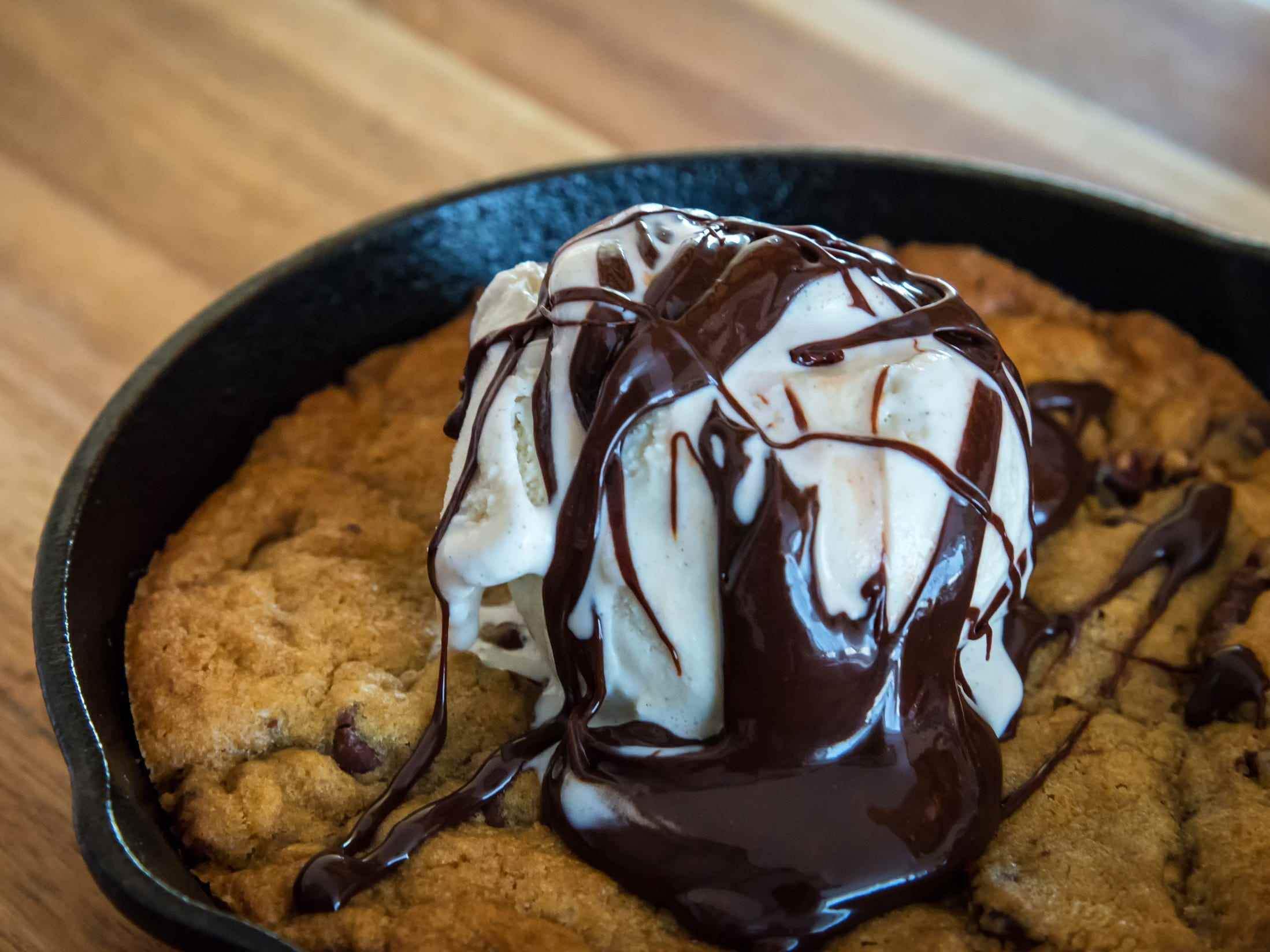 Chocolate Chip Cookie, gebacken in einer gusseisernen Pfanne, garniert mit Vanilleeis und Schokoladensauce