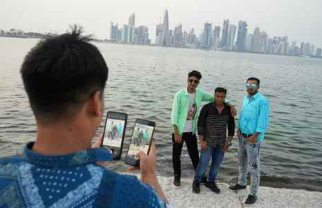 Bangladescher posieren an einem Feiertag an der Corniche in Doha mit den Wolkenkratzern und der Skyline der Stadt im Hintergrund.