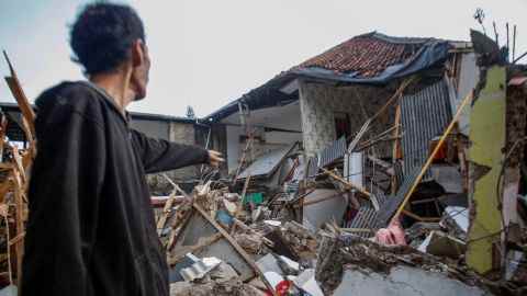 Ein Mann steht in der Nähe von Häusern, die nach einem Erdbeben in Cianjur, Provinz West-Java, Indonesien, am 21. November 2022 beschädigt wurden.