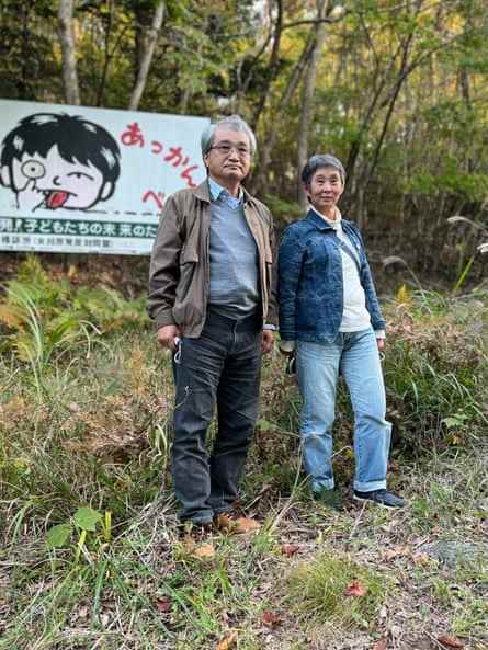 Tsuyoshi Suda, links, und Mikiko Abe, Stadträtin von Onagawa, vor einem Schild, das sich gegen das örtliche Kernkraftwerk wendet.