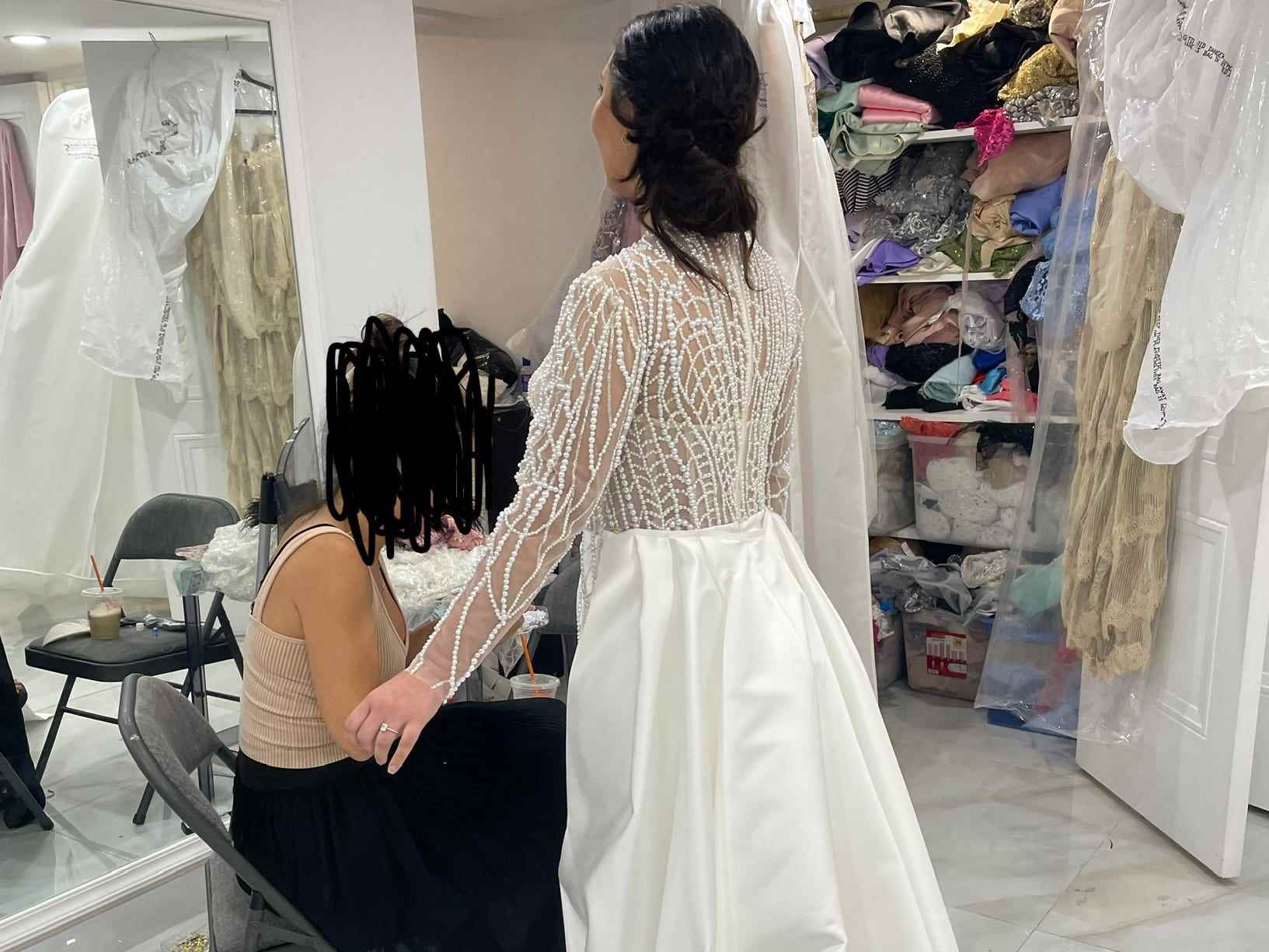 Pepa probiert das individuelle Hochzeitskleid an, mit der Rückseite zur Kamera