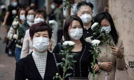 Eine Gruppe von Frauen trägt Chrysanthemen, um dem ehemaligen chinesischen Führer ihre Ehrerbietung zu erweisen.