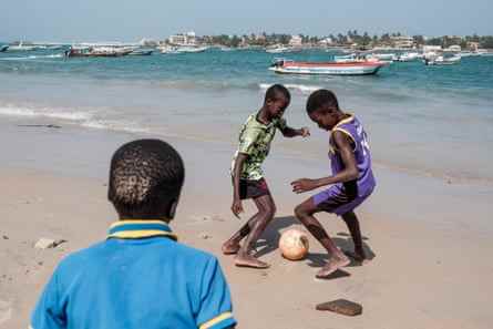 Jungen spielen Fußball am Strand von N'Gor in Dakar.  Viele, die nicht zur Schule gehen, verbringen ihre Tage mit Freunden und spielen das Spiel auf der Straße oder an den vielen Stränden rund um Dakar.