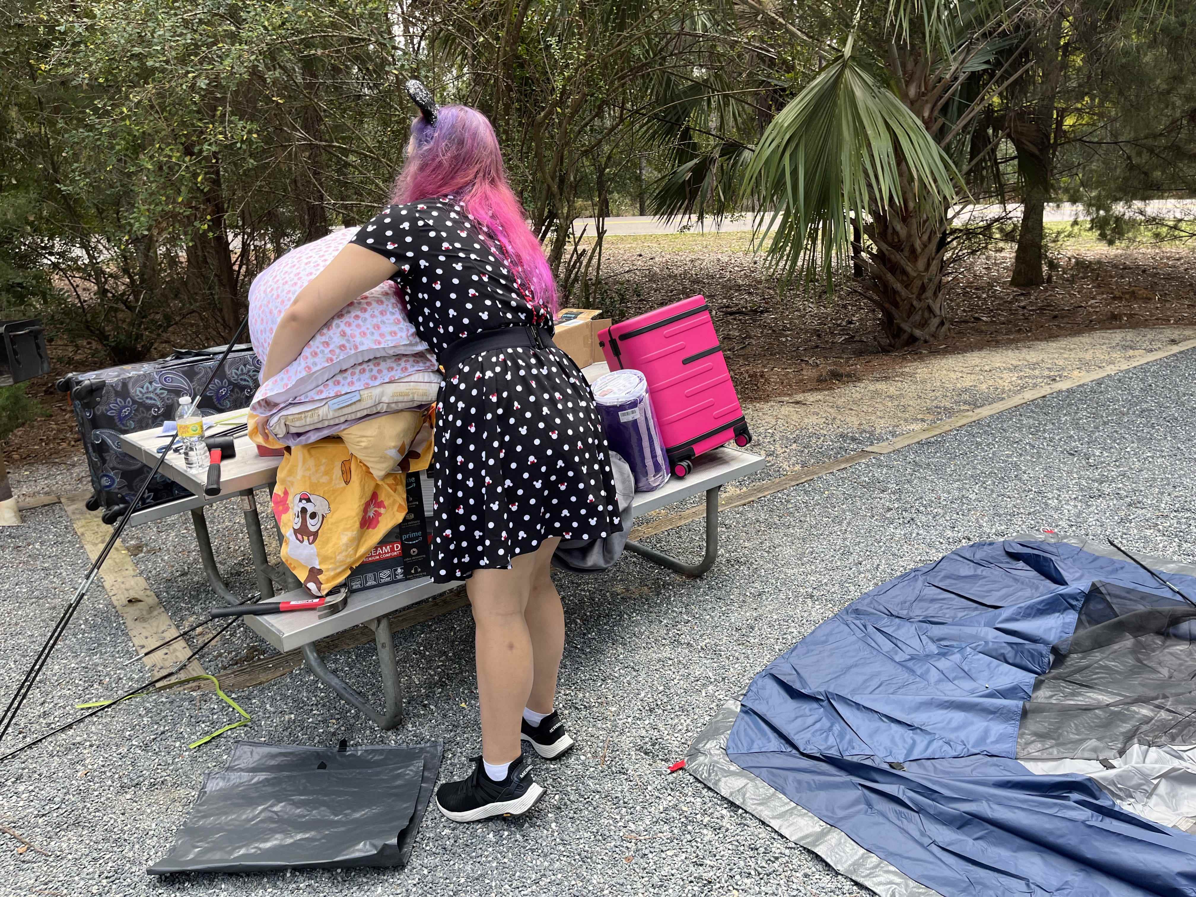 Jenna Clark handhabt Campingausrüstung auf einem Picknicktisch