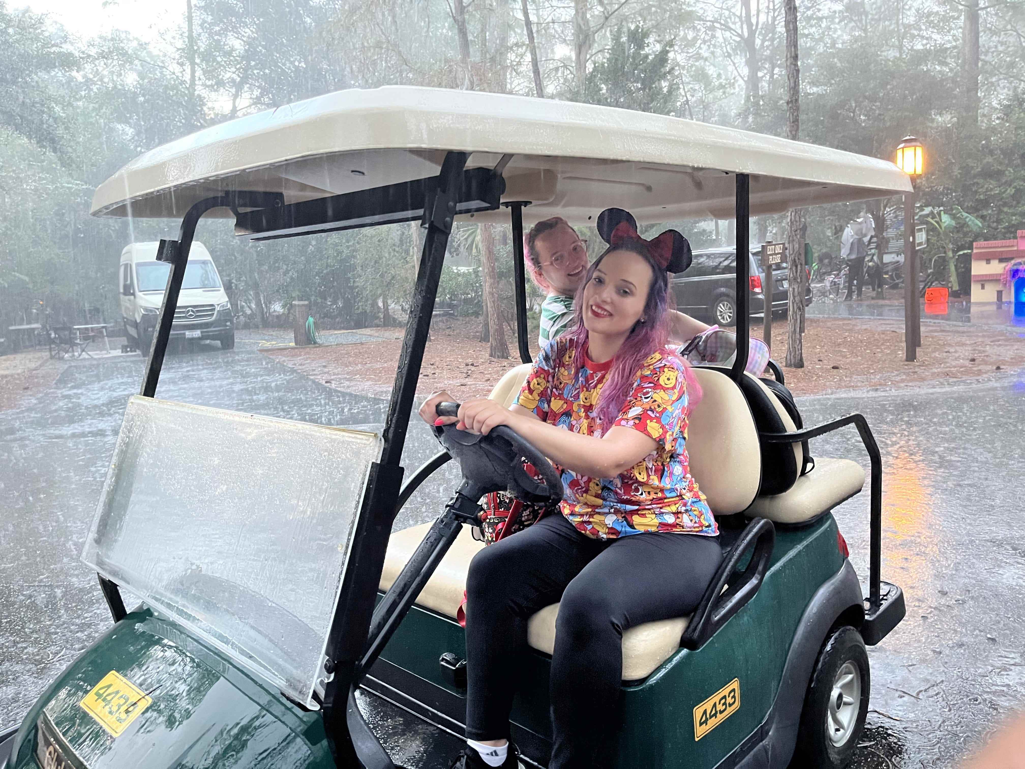 Jenna Clark fährt den Golfwagen im Regen