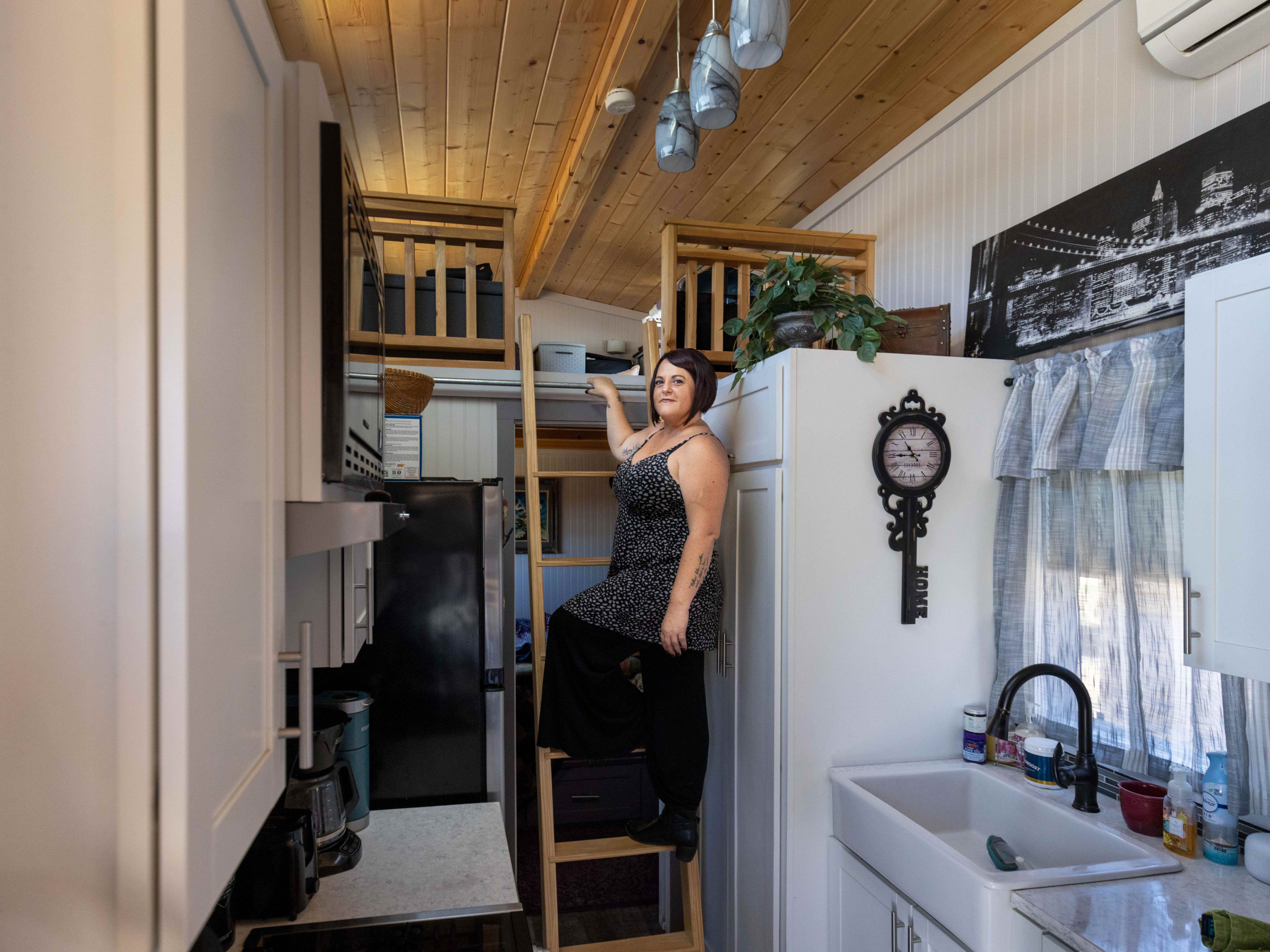 Chasidy Decker, 46, steht in ihrem winzigen Haus auf der Leiter, die zu ihrem Schlafzimmer hinaufführt.