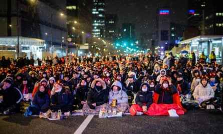 Fans von Südkorea verfolgen das Spiel auf einer großen Leinwand, während es in Seoul schneit