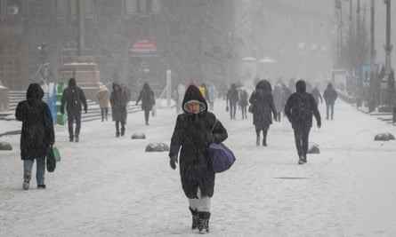 Menschen gehen am Mittwoch durch den Schnee im Zentrum von Kiew, Ukraine.
