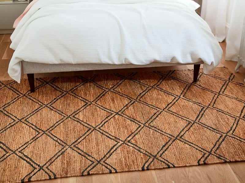 Bild eines braunen Teppichs mit schwarzem Design von West Elm unter einem Bett für beste Teppiche
