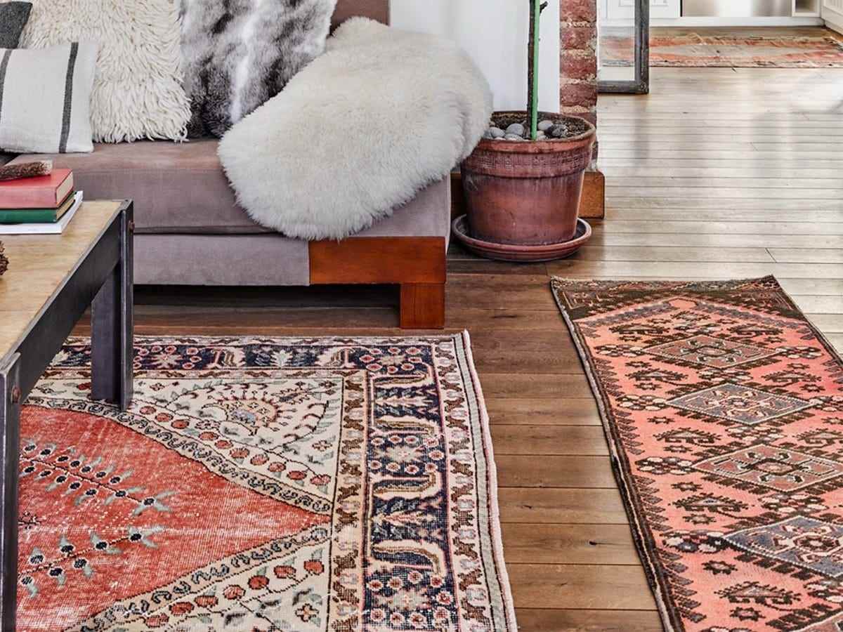 Bild von zwei mehrfarbig gemusterten Revival Rugs-Teppichen neben einer Couch und unter einem Couchtisch für die besten Teppiche