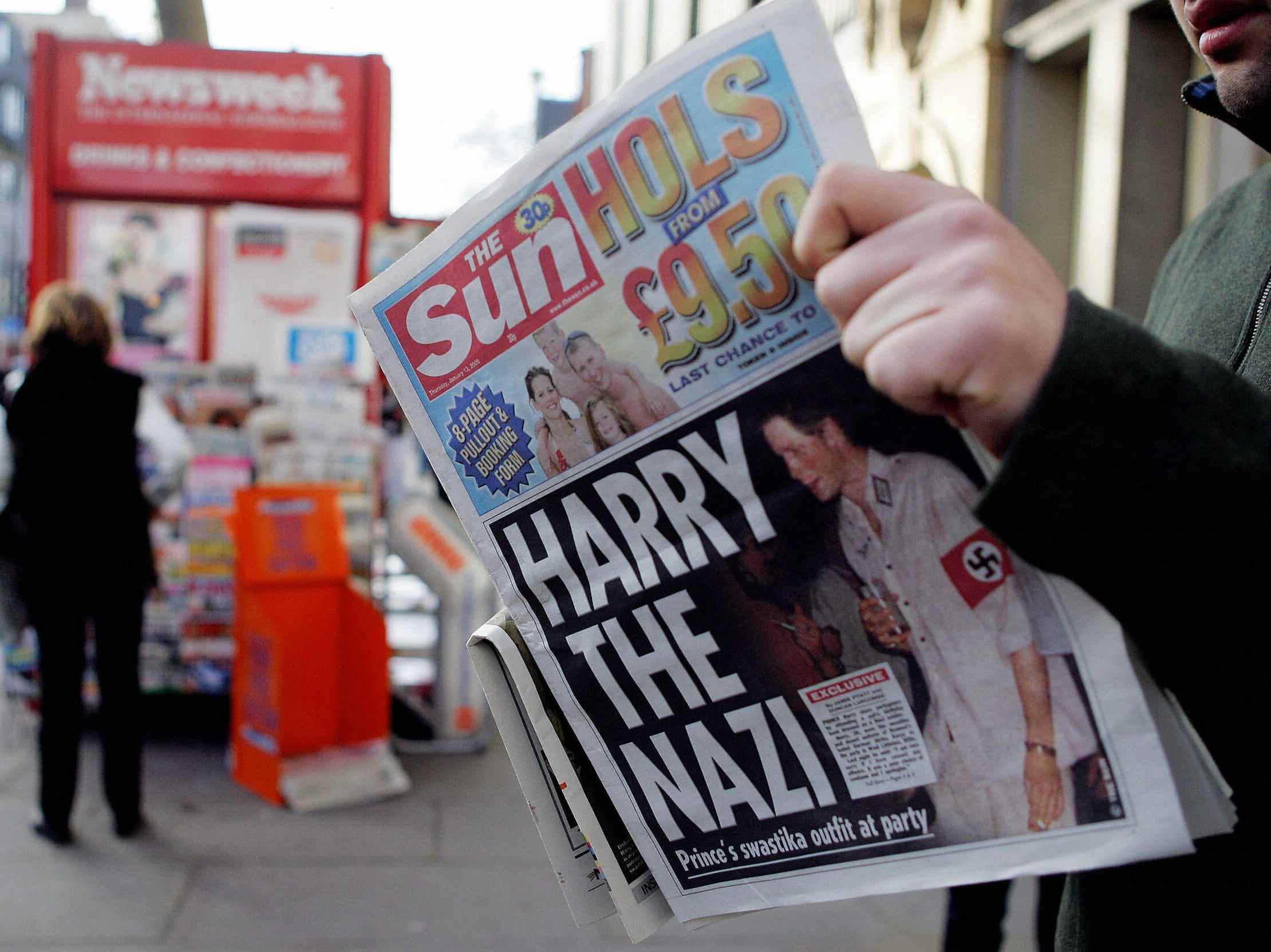 Ein Mann liest am 13. Januar 2005 in London die Zeitung The Sun mit einer Schlagzeile über Prinz Harry, der auf einer Kostümparty eine Nazi-Uniform trägt.