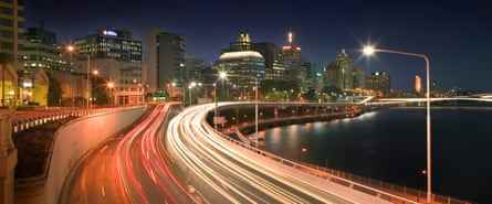 Langzeitbelichtungsfoto von Brisbanes Riverside Expressway bei Nacht, das Linien von Autolichtern auf der Straße zeigt