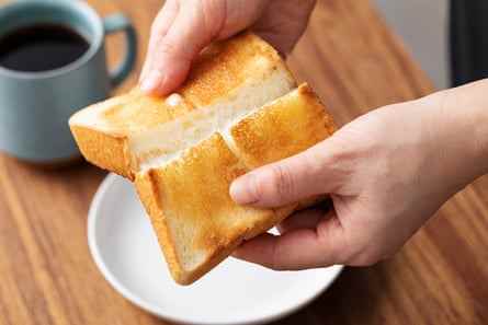 Hände brechen ein Stück Toast