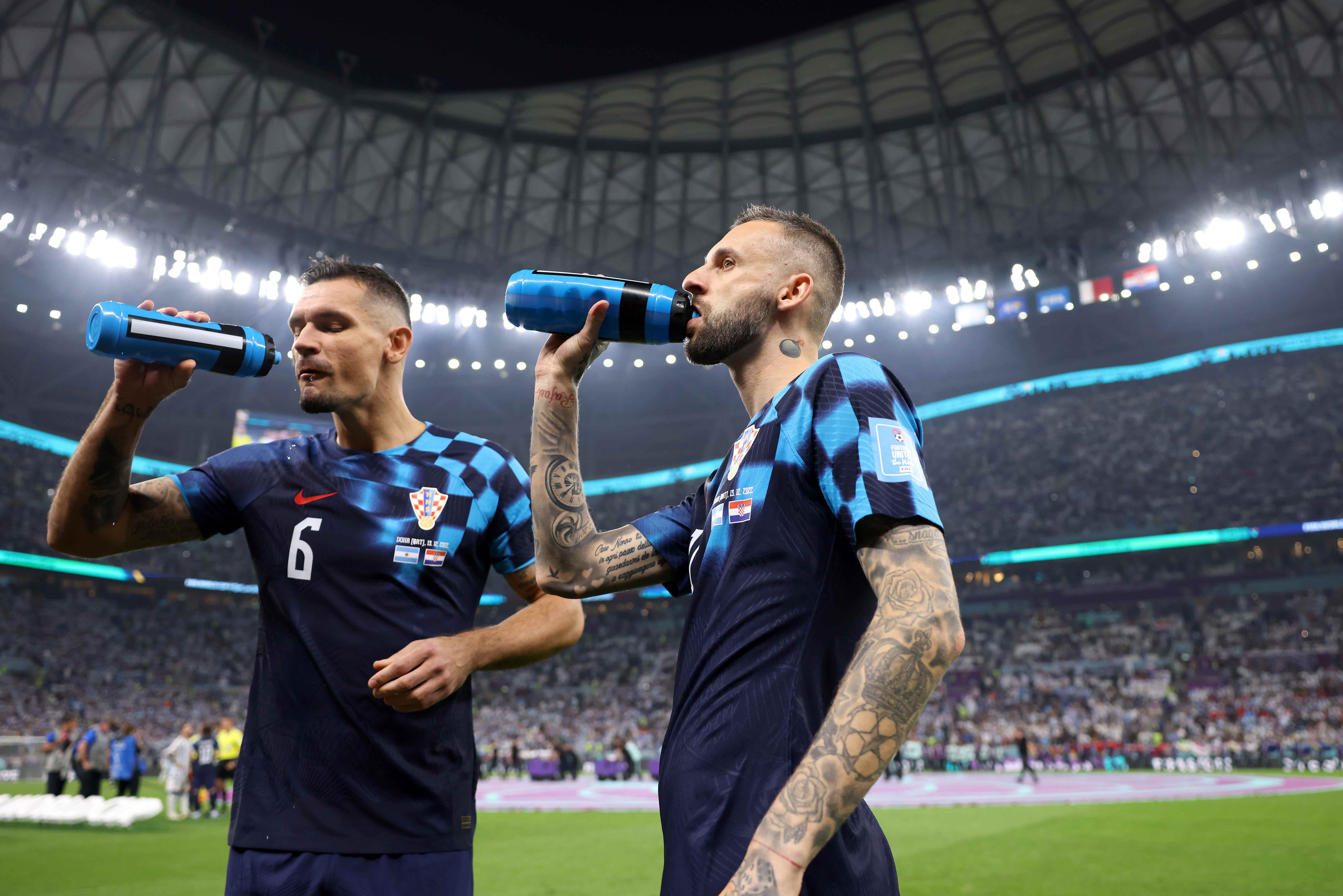 Zwei argentinische Spieler trinken während eines WM-Spiels etwas.