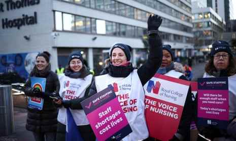 Krankenschwestern streiken vor dem St. Thomas' Hospital in LondonEine Krankenschwester winkt, als sie und andere während eines Streiks vor dem St. Thomas' Hospital in London, Großbritannien, am 15. Dezember 2022 Schilder halten. REUTERS/Henry Nicholls