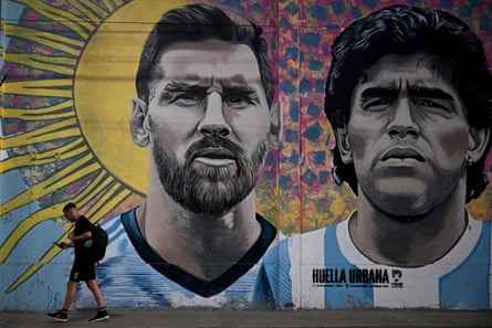Ein Mann geht an einem Wandgemälde vorbei, das Lionel Messi und Diego Maradona in Buenos Aires darstellt.