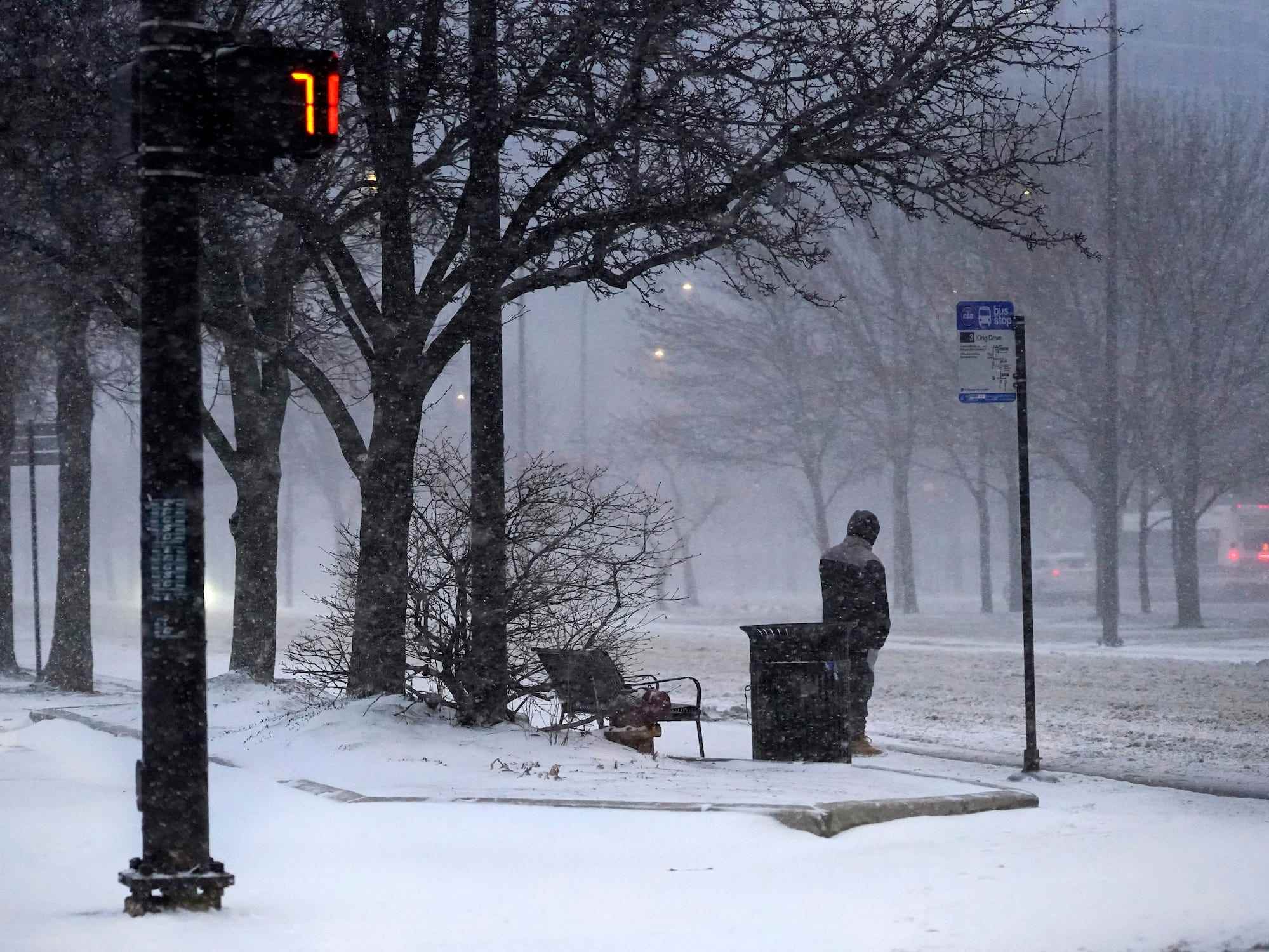 Ein Transitfahrer wartet auf einen Bus, während ein Wintersturm am Donnerstag, den 17. Februar 2022, über Chicago hereinbricht.
