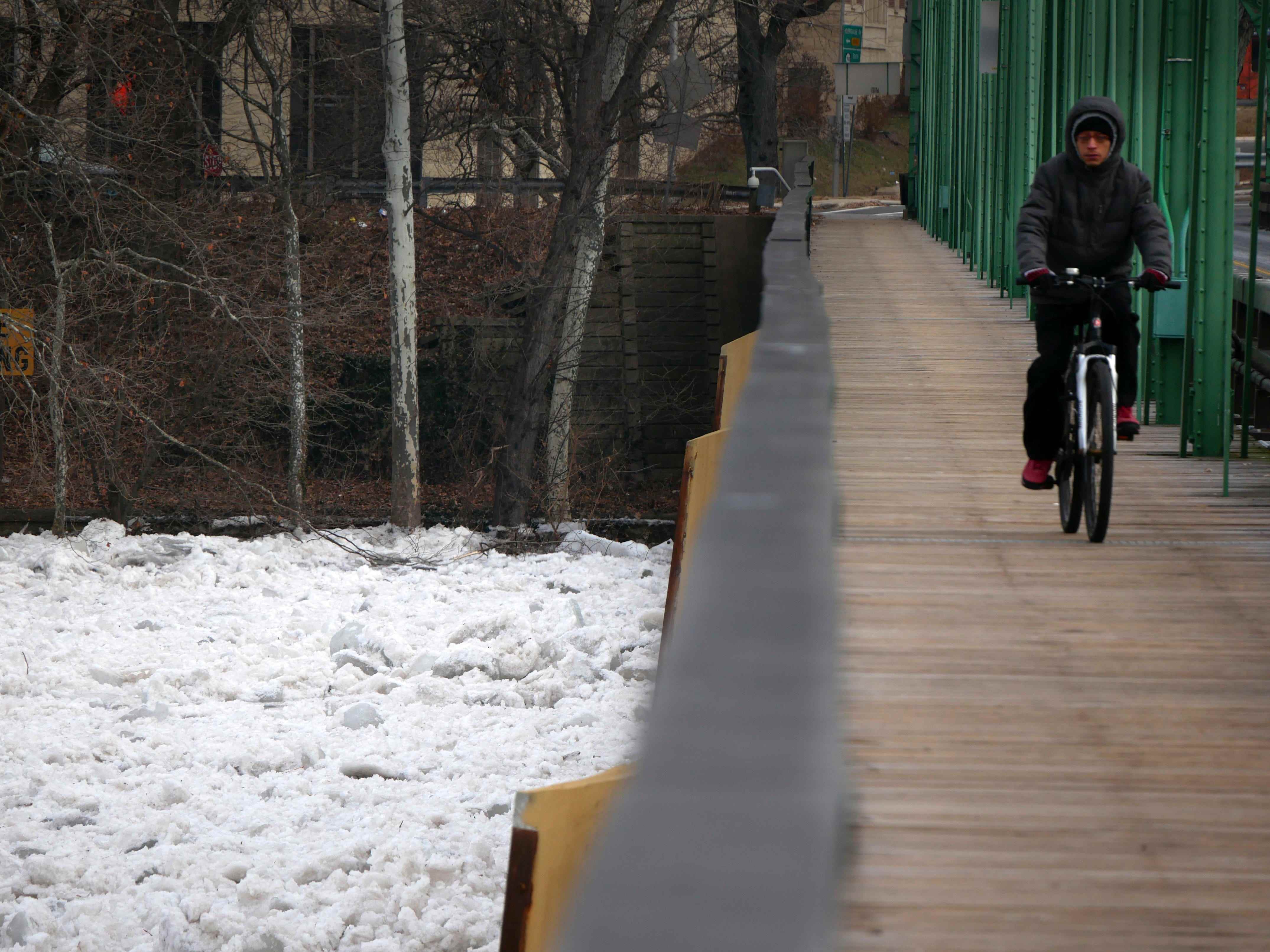 Ein Mann fährt mit dem Fahrrad über eine Brücke, die den teilweise zugefrorenen Delaware River in Trenton, NJ, überspannt, Dienstag, 16. Januar 2018.