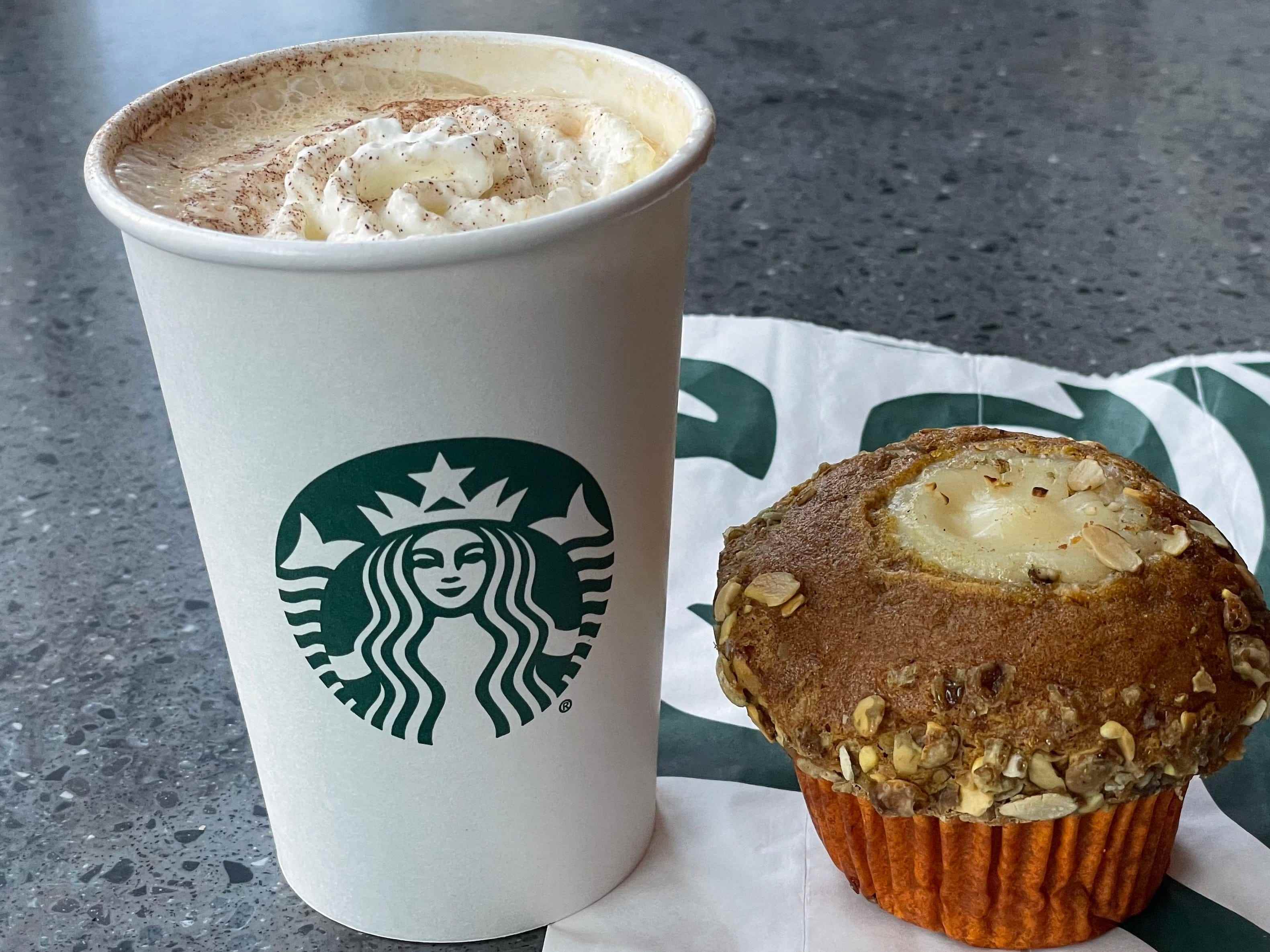 Pumpkin Spice Latte von Starbucks neben einem Pumpkin Cream Cheese Muffin