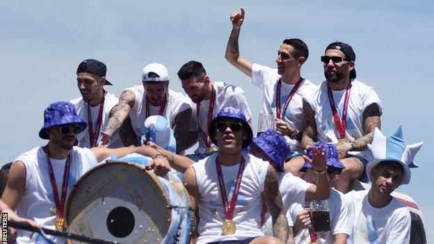 Argentiniens Spieler – einschließlich Kapitän Lionel Messi – feiern mit ihren begeisterten Fans während der Parade am Dienstag in einem offenen Bus