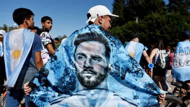 Argentinien-Fans tragen eine Lionel-Messi-Flagge über seinen Schultern