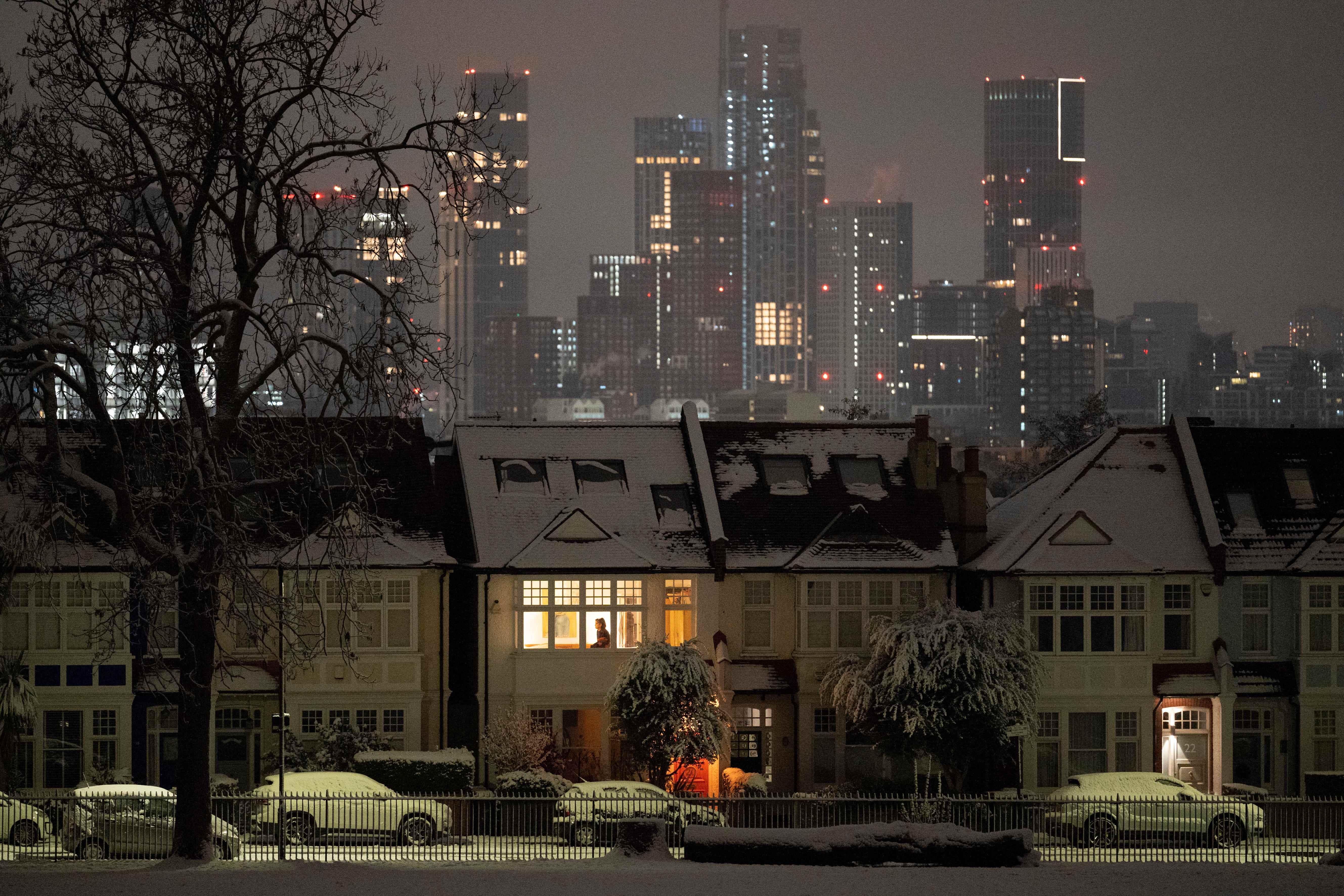 Eine Person bereitet sich an einem kühlen Montagmorgen in einem Wohnhaus nach niedrigen Temperaturen und nächtlichem Schneefall auf Häusern im Süden Londons im Ruskin Park in SE24 am 12. Dezember 2022 in London, England, vor.
