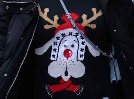 Ein Käufer trägt einen Weihnachtspullover, als er im Dezember 2022 an Geschäften in der Oxford Street im Zentrum von London vorbeigeht