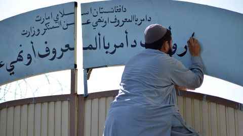 Ein Mitglied der Taliban ersetzt im Oktober 2021 an einem Regierungsgebäude in Kandahar, Afghanistan, ein Schild der Abteilung für Frauenangelegenheiten durch eines des Ministeriums für die Förderung der Tugend und die Verhinderung von Lastern.