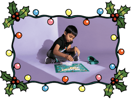 Ein Foto eines Jungen, der Scrabble in einem Rahmen mit Stechpalme und Weihnachtsbeleuchtung spielt