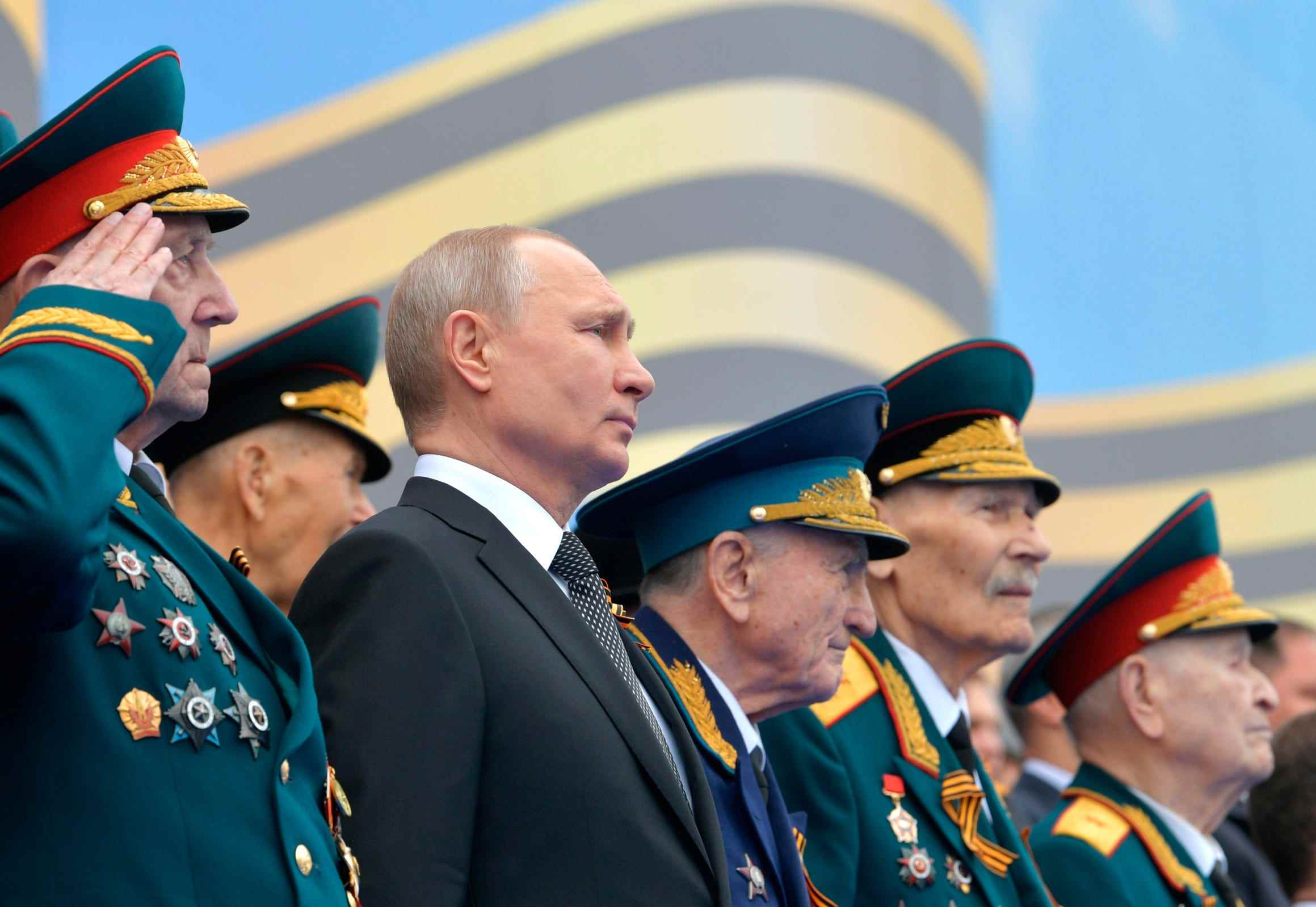 Umgeben von Veteranen des Zweiten Weltkriegs beobachtet der russische Präsident Wladimir Putin die Militärparade zum 74. Jahrestag des Sieges im Zweiten Weltkrieg auf dem Roten Platz in Moskau, Russland, Donnerstag, 9. Mai 2019.