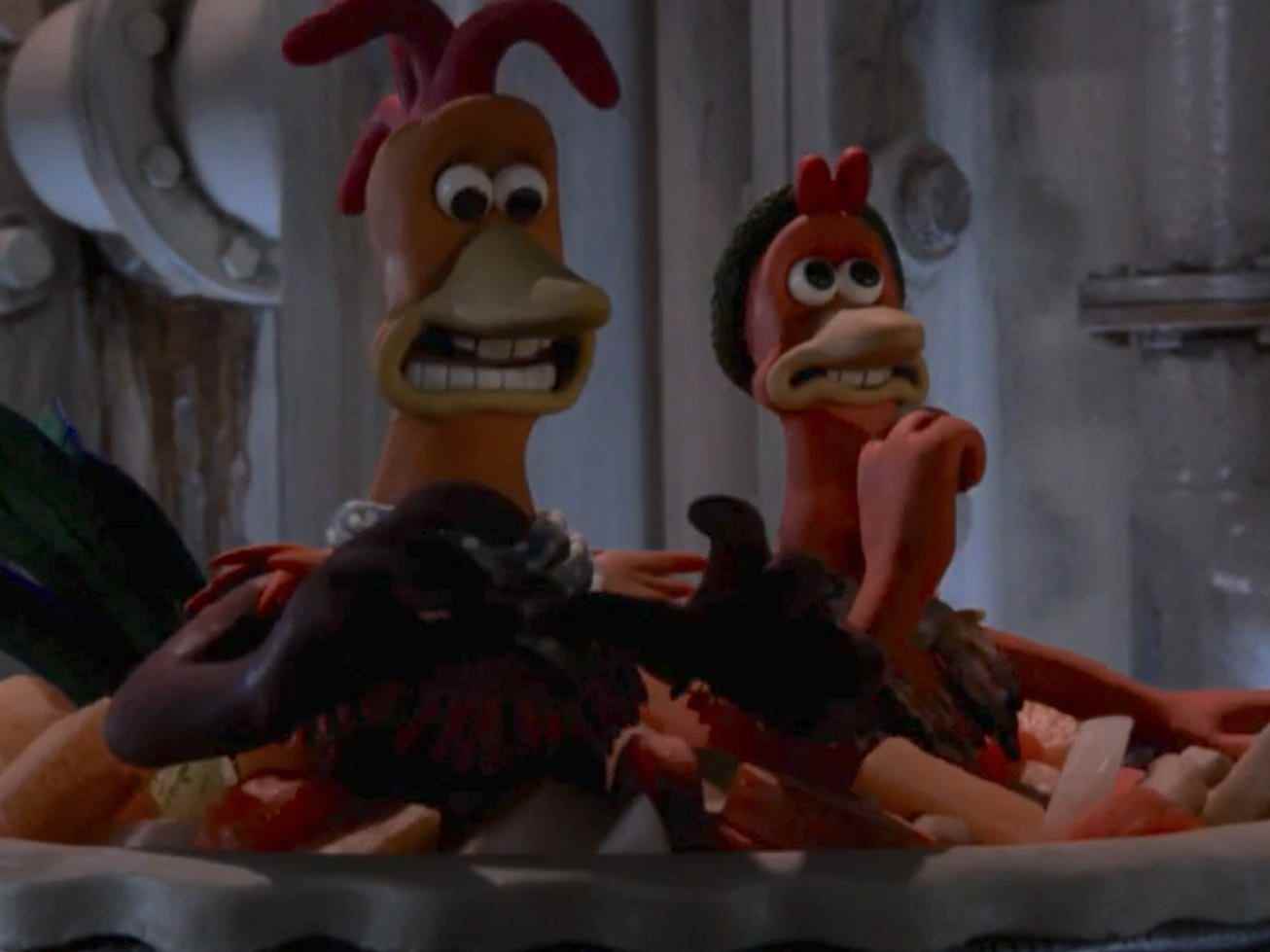zwei Stop-Motion-animierte Hühner in offensichtlicher Gefahr, deren Köpfe aus einer mit Gemüse gefüllten Pastetenkruste ragen
