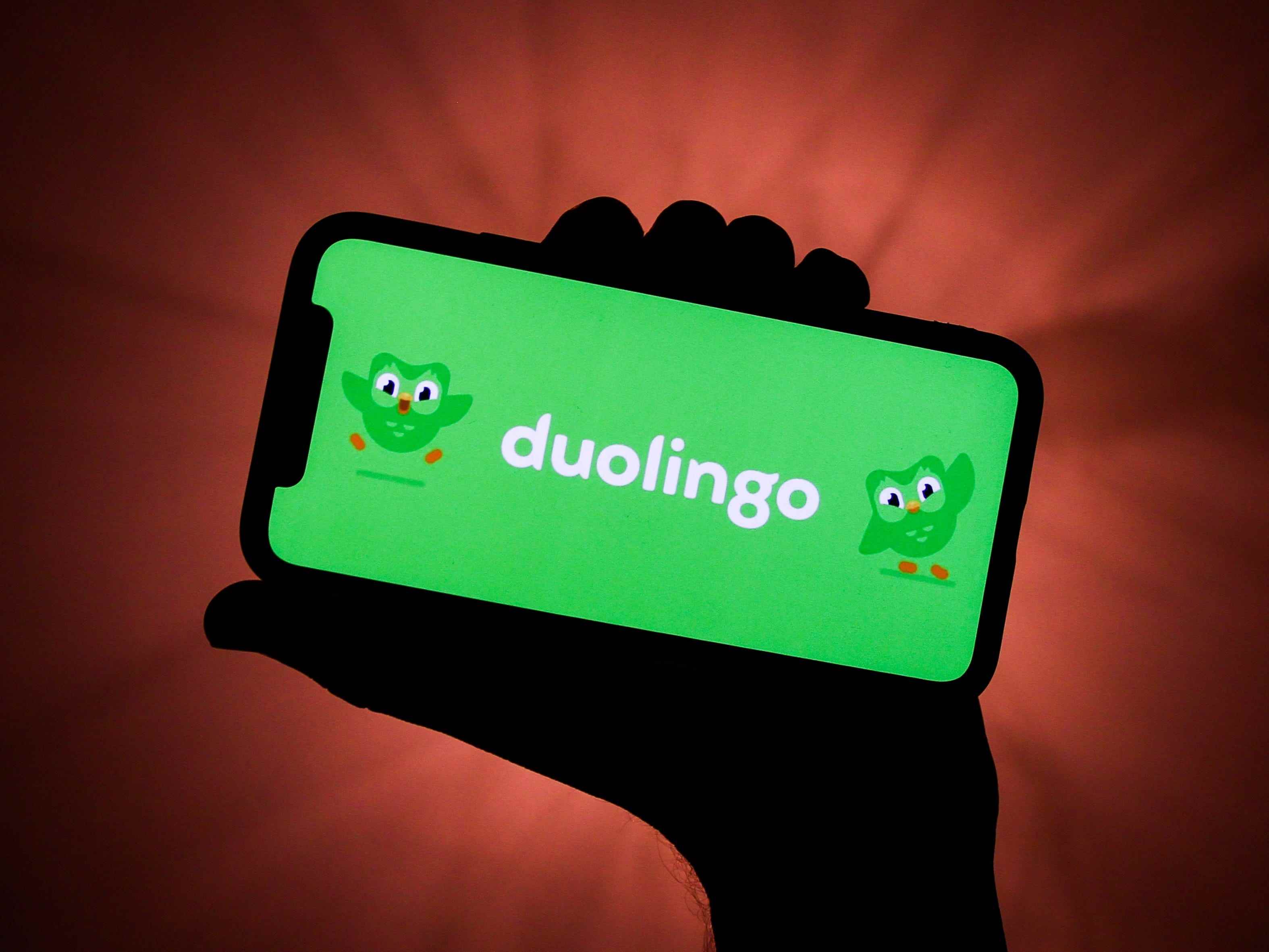 Hand, die Telefon mit Duolingo-Startbildschirm hält.
