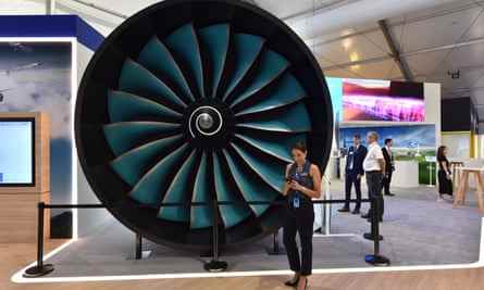 Ein Mitarbeiter steht auf der Farnborough International Airshow neben einem maßstabsgetreuen Modell des neuen Rolls-Royce UltraFan-Triebwerks