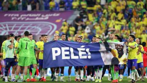Brasilianische Spieler halten nach dem Achtelfinalspiel der FIFA Fussball-Weltmeisterschaft Katar 2022 zwischen Brasilien und Südkorea am 5. Dezember ein Banner, das ihre Unterstützung für den ehemaligen brasilianischen Spieler Pele zeigt. 