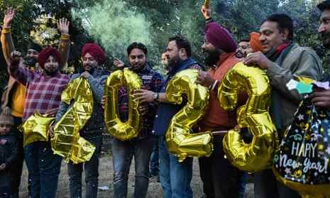 Während der Feierlichkeiten am Vorabend des neuen Jahres in Amritsar am 31. Dezember 2022 halten Menschen numerisch geformte Luftballons.