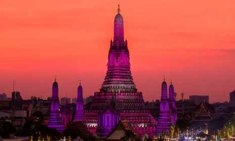 Die Sonne geht am Silvesterabend in Bangkok hinter Wat Arun oder dem Tempel der Morgenröte unter. Lichter beleuchten Wat Arun oder den Tempel der Morgenröte an Silvester in Bangkok, Thailand, 31.
